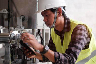 Kırpılmış görüntü Yöneticisi Teknik Endüstriyel Mühendis, tablet üzerinde izleme sistemi yazılımı ve sanayi ağı bağlantısı ile robotları çalışıyor ve kontrol ediyor.