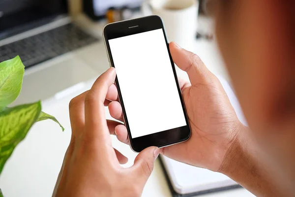 Mock up smartphone of hand holding black mobile phone with blank white screen.