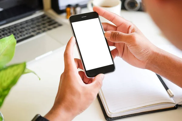 Modern ofisin bulanık arka planına sahip akıllı telefon kullanan erkek elleri yakın plan görüntüsü. Grafik görüntüleme için boş ekran monitörü.