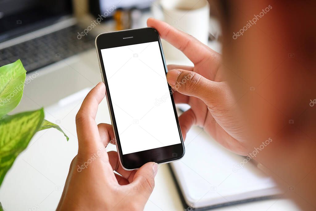 Mock up smartphone of hand holding black mobile phone with blank white screen.	