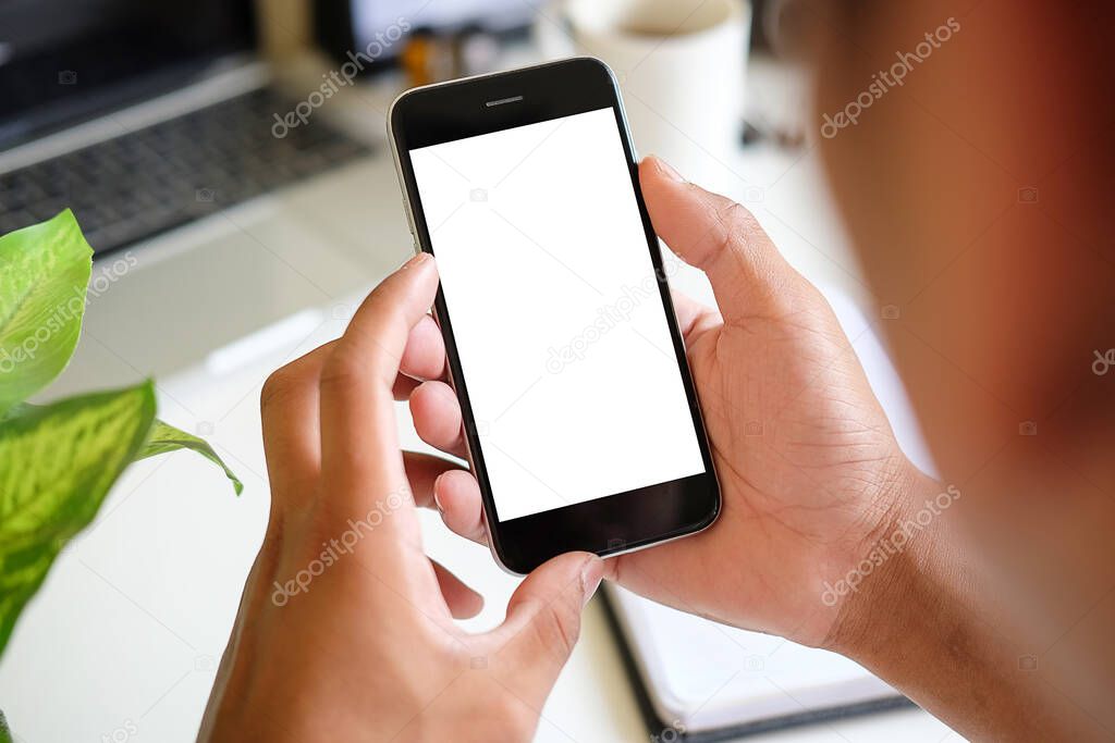 Mock up smartphone of hand holding black mobile phone with blank white screen.	