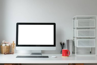 Boş ekranlı ve beyaz masadaki ekipmanlı modern çalışma alanı. Bilgi için boş ekran.