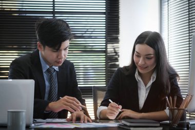 Business people analysing and discussing online data with laptop computer in office.	