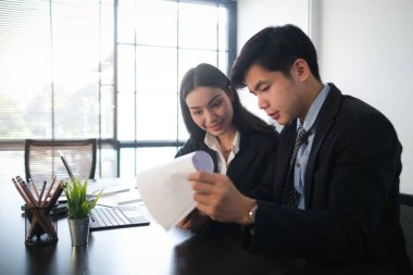 İş adamları ofisteki dizüstü bilgisayarla çevrimiçi verileri analiz ediyor ve tartışıyor.