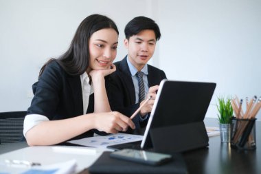 İş adamları ofisteki dizüstü bilgisayarla çevrimiçi verileri analiz ediyor ve tartışıyor.