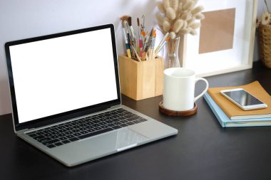 Boş ekranlı ve beyaz masadaki ekipmanlı modern çalışma alanı. Bilgi için boş ekran