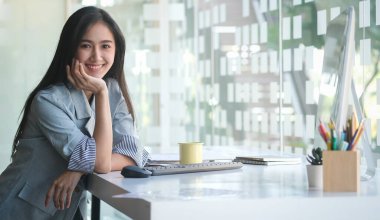 A young female administrative assistant making notes of working planning organizing information in her office.	