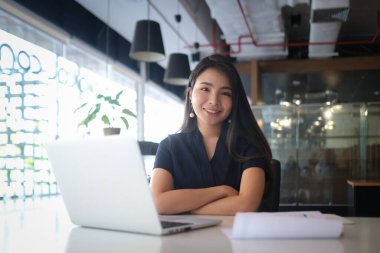 A young female administrative assistant making notes of working planning organizing information in her office.	