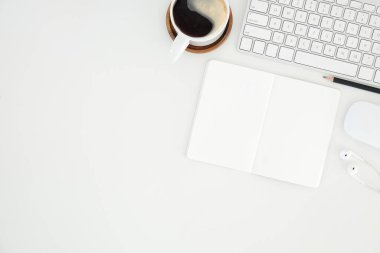 Not defteri, dizüstü bilgisayar ve kahve fincanı fare notlu üst görünüm ofis malzemeleri. Boş ekran cep telefonu ve masa başı çalışma alanı üzerindeki malzemeler ve kopyalama alanı..