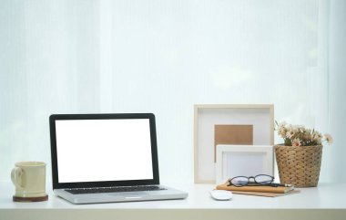 Boş ekranlı ve beyaz masadaki ekipmanlı modern çalışma alanı. Bilgi için boş ekran.