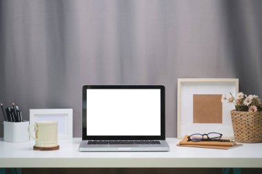 Boş ekranlı ve beyaz masadaki ekipmanlı modern çalışma alanı. Bilgi için boş ekran.