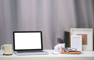 Boş ekranlı ve beyaz masadaki ekipmanlı modern çalışma alanı. Bilgi için boş ekran.
