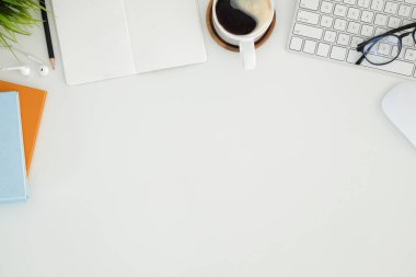 Beyaz masadaki dijital tablet, kahve fincanı ve not defteri olan grafik tasarımcı ya da fotoğrafçı çalışma alanının üst görüntüsü. Metin reklamı için boş ekran.