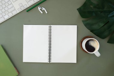 Beyaz masadaki dijital tablet, kahve fincanı ve not defteri olan grafik tasarımcı ya da fotoğrafçı çalışma alanının üst görüntüsü. Metin reklamı için boş ekran.