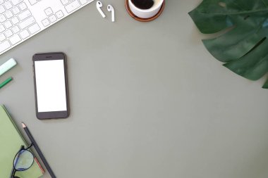 Beyaz masadaki dijital tablet, kahve fincanı ve not defteri olan grafik tasarımcı ya da fotoğrafçı çalışma alanının üst görüntüsü. Metin reklamı için boş ekran.