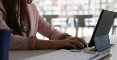 Kağıt belgelerinin istatistiklerini kontrol eden ve ofis masasındaki tablet bilgisayarda çalışan ofis çalışanlarının kırpılmış görüntüleri..