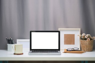 Boş ekranlı ve beyaz masadaki ekipmanlı modern çalışma alanı. Bilgi için boş ekran.