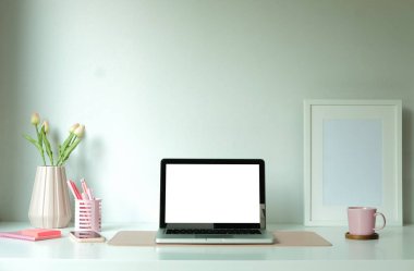 Boş ekranlı ve beyaz masadaki ekipmanlı modern çalışma alanı. Bilgi için boş ekran.