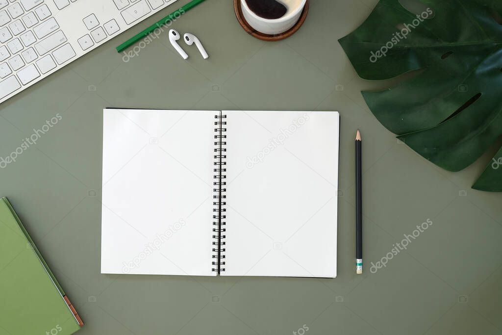 Top view of a graphic designer or photographer workspace with digital tablet, coffee cup, and notebook on white table. Blank screen for advertise text.