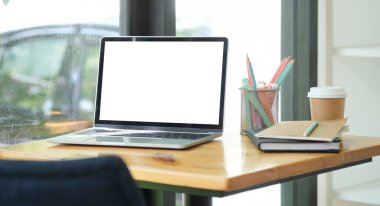 Çalışma masası ve dizüstü bilgisayar. İş resmi, boş ekran dizüstü bilgisayar ve malzemeler..