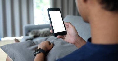 Metin mesajınız veya bilgi içeriğiniz için boş ekranlı akıllı telefonu tutan erkek eli görüntüsü, şehir ortamında cep telefonundan mesaj okuyan kadın görüntüsü.