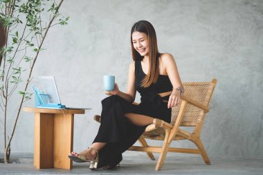 İş kadını evrak işleri hakkında bilgi okuyor ve masa başında bilgisayar kullanıyor..