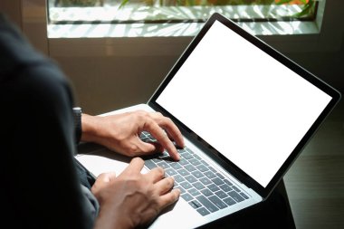 Back view of young businessman working on new project with computer tablet at his home office.	