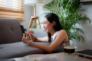 Mutlu kadın evde dinleniyor ve tabletle internette sörf yapıyor..