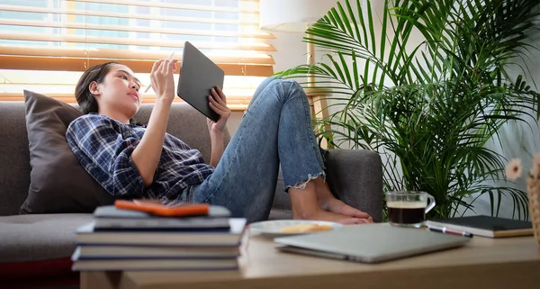 Smiling Young Woman Sitting Comfortable Sofa Using Digital Tablet — стокове фото