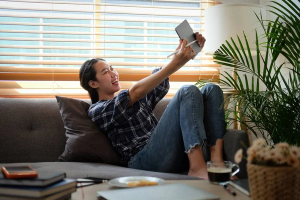 Smiling Young Woman Sitting Comfortable Sofa Using Digital Tablet — стокове фото