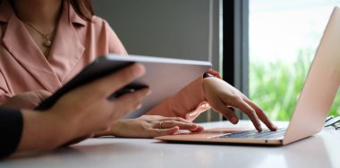 Ofis masasında mali iş grafiği diyagramı olan bir tablet bilgisayarda çalışan işadamının görüntüsünü kapat.