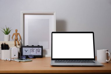 Beyaz ekranlı dizüstü bilgisayar ve ahşap masada kahve fincanı. Grafik görüntüleme kurgusu için boş ekran.