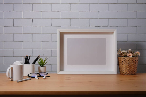 Modern workspace desk and copy space book, plant and coffee cup on wood desk.