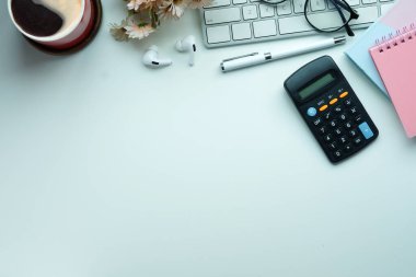 Hesap makinesi, defter, bardak ve kahve fincanı ofis masasında..