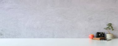 Boş çerçeve, ev bitkisi ve kamera beyaz masada.