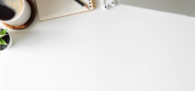 Not defteri, dizüstü bilgisayar ve kahve fincanı fare notlu üst görünüm ofis malzemeleri. Boş ekran cep telefonu ve beyaz masa çalışma alanı üzerindeki malzemeler ve kopyalama alanı..