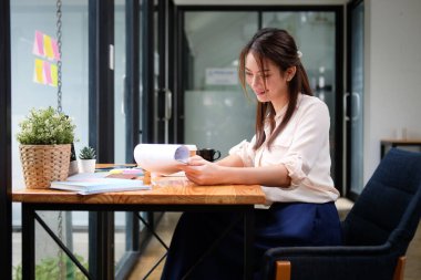 Ofisteki mali belgeleri analiz eden güzel bir iş kadını.