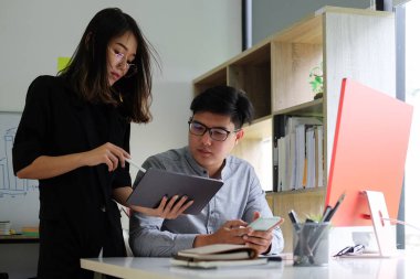 İki iş adamı iş verilerini dijital tabletle tartışıyor.