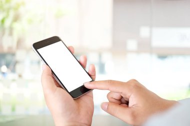 Metin mesajınız veya bilgi içeriğiniz için boş ekranlı akıllı telefonu tutan erkek eli görüntüsü, şehir ortamında cep telefonundan mesaj okuyan kadın görüntüsü. 
