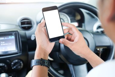 Kesilmiş görüntü. Şoför araba kullanırken telefonu kullanıyor. Yuvarlak kenarlı modern akıllı telefon. Model için izole ekran. Arka planda araba navigasyon görüntüsü. 