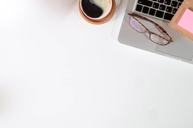 Not defteri, dizüstü bilgisayar ve kahve fincanı fare notlu üst görünüm ofis malzemeleri. Boş ekran cep telefonu ve beyaz masa çalışma alanı üzerindeki malzemeler ve kopyalama alanı..