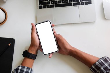 Metin mesajınız veya bilgi içeriğiniz için boş ekranlı akıllı telefonu tutan erkek eli görüntüsü, şehir ortamında cep telefonundan mesaj okuyan kadın görüntüsü. 