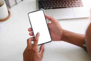 Metin mesajınız veya bilgi içeriğiniz için boş ekranlı akıllı telefonu tutan erkek eli görüntüsü, şehir ortamında cep telefonundan mesaj okuyan kadın görüntüsü. 