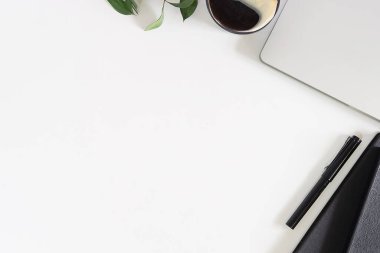 Not defteri, dizüstü bilgisayar ve kahve fincanı fare notlu üst görünüm ofis malzemeleri. Boş ekran cep telefonu ve beyaz masa çalışma alanı üzerindeki malzemeler ve kopyalama alanı..