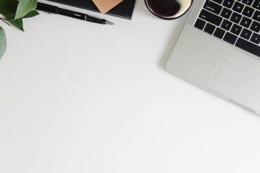 Not defteri, dizüstü bilgisayar ve kahve fincanı fare notlu üst görünüm ofis malzemeleri. Boş ekran cep telefonu ve beyaz masa çalışma alanı üzerindeki malzemeler ve kopyalama alanı..