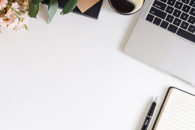 Not defteri, dizüstü bilgisayar ve kahve fincanı fare notlu üst görünüm ofis malzemeleri. Boş ekran cep telefonu ve beyaz masa çalışma alanı üzerindeki malzemeler ve kopyalama alanı..