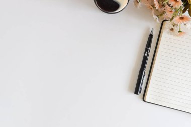 Not defteri, dizüstü bilgisayar ve kahve fincanı fare notlu üst görünüm ofis malzemeleri. Boş ekran cep telefonu ve beyaz masa çalışma alanı üzerindeki malzemeler ve kopyalama alanı..