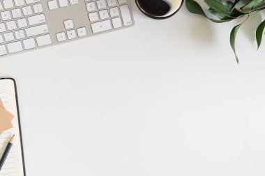 Not defteri, dizüstü bilgisayar ve kahve fincanı fare notlu üst görünüm ofis malzemeleri. Boş ekran cep telefonu ve beyaz masa çalışma alanı üzerindeki malzemeler ve kopyalama alanı..