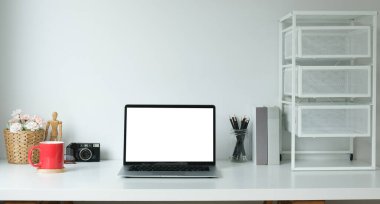 Minimal workspace with white screen computer and office supplies on white table.	