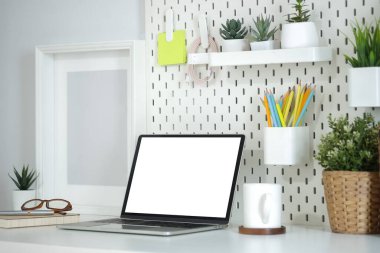 Boş ekran, kahve fincanı ve ev bitkisini beyaz masaya dizin..